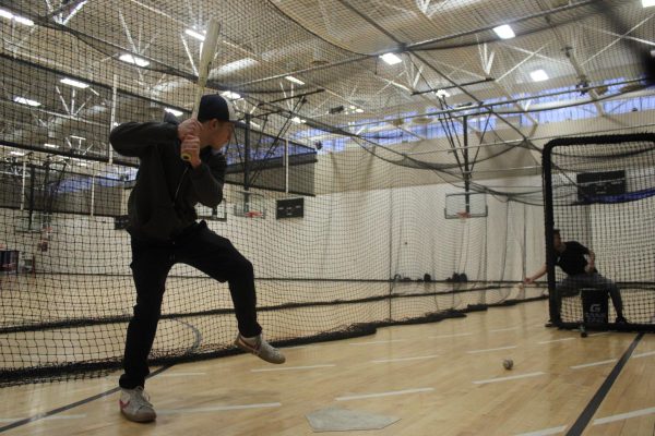 Sophomore Kyler Althoff swings at a pitch in the fieldhouse Feb 24. He prepares to bounce back into the baseball season after an injury.