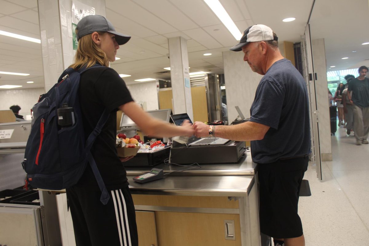 Freshman Phillip Gerlach receives a fist bump from lunchworker Jake Schleppencach May 28. At Park, cafeteria staff often serve up meals and greet students with positive encouragement during lunch.